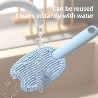 Blue pet hair comb rinsing under running water for quick cleaning